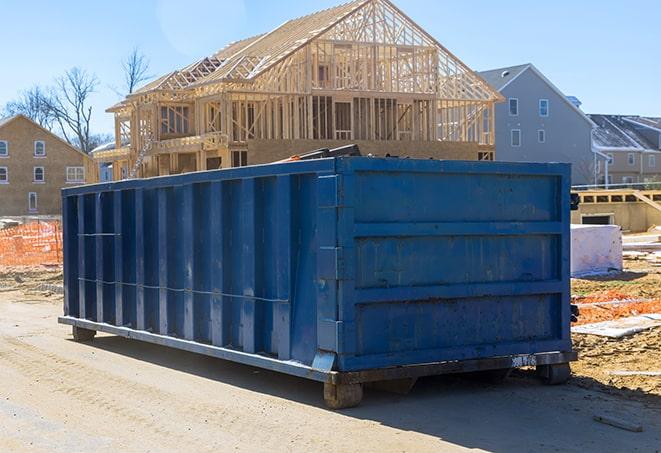 a row of residential dumpsters parked on a driveway